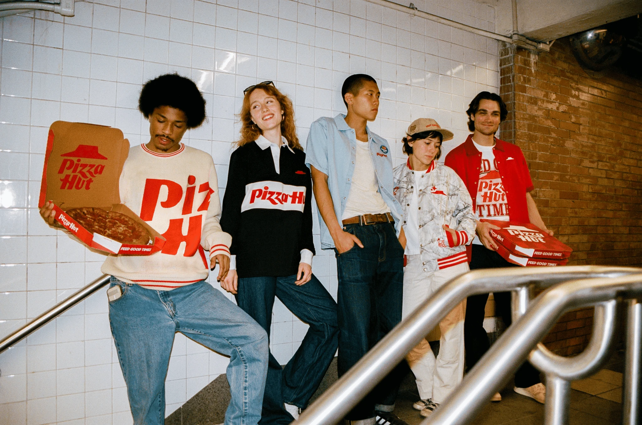 Friends wearing Pizza Hut clothing and holding pizza boxes